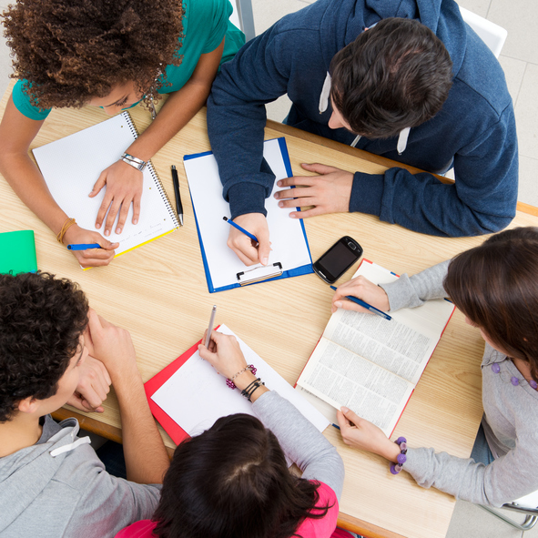 Group of young students studying together at college.